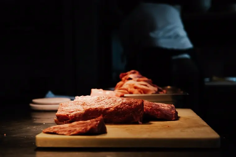 Cuts of raw beef resting on a wooden board