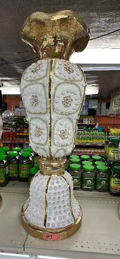 A white and gold patterned vase above the tea shelf